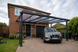 Anthracite grey PolycarbonateX carport with bronze 25mm multiwall polycarbonate sheets installed on a detached British family home.