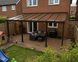 Bronze multiwall polycarbonate lean-to roof with brown PolycarbonateX glazing bars and accessories installed on a typical British family home.