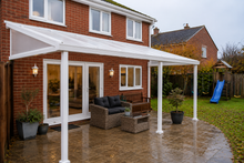 White PolycarbonateX patio roof with 25mm opal multiwall polycarbonate sheets installed on a British family home during light rain.